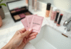 Main d'une femme tenant des sachets Sephora sur un vanity en marbre blanc