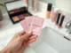 Main d'une femme tenant des sachets Sephora sur un vanity en marbre blanc